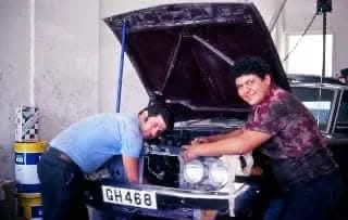 Historic MILIKOUROS family workshop photo with mechanics working on a car